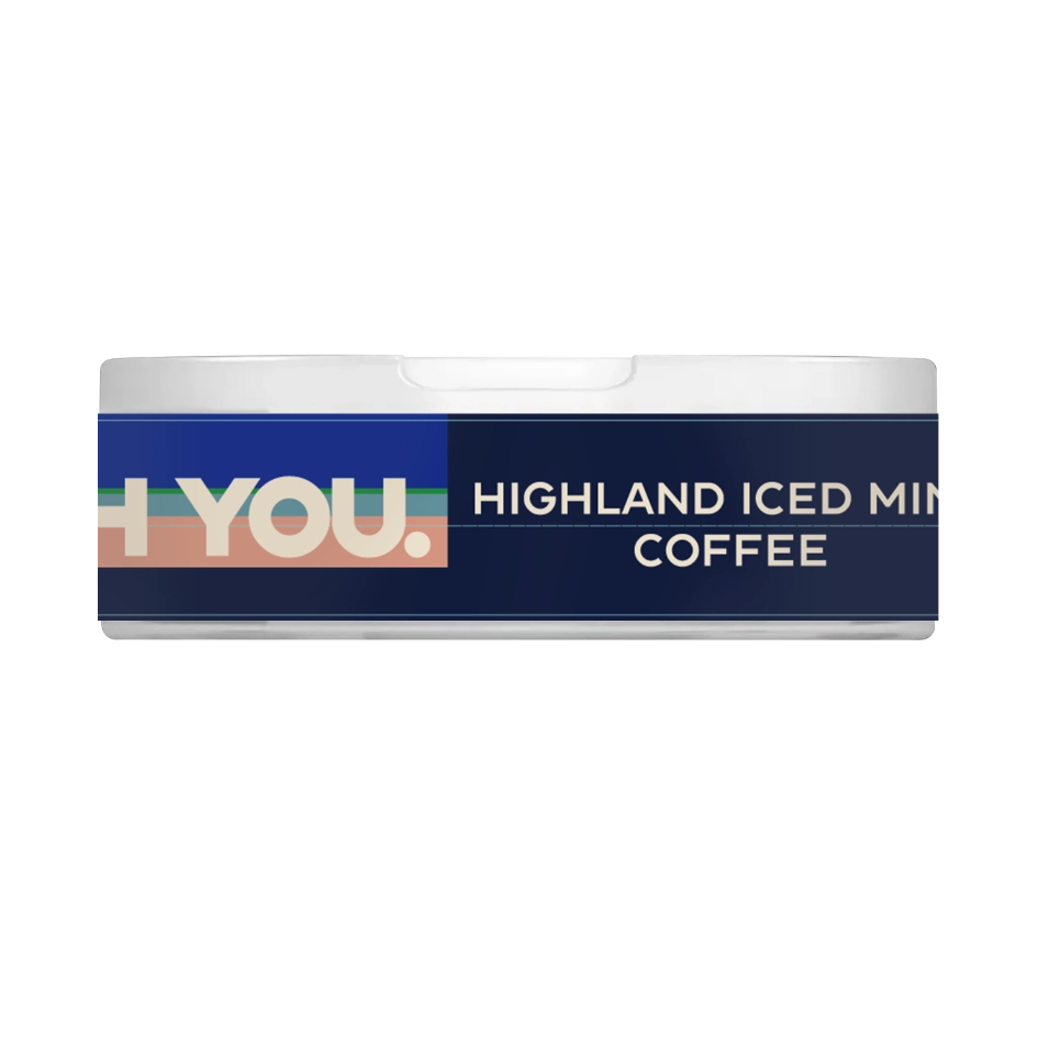 Hands holding HIGHLAND ICED MINT COFFEE Flavor 50mg caffeine COFFEE POUCHES THE FORCE SENSE LABS pouch with a cup of iced coffee in the background